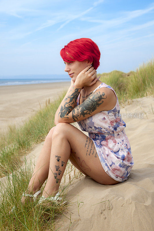 在海滩上穿着迷你裙的红发女郎