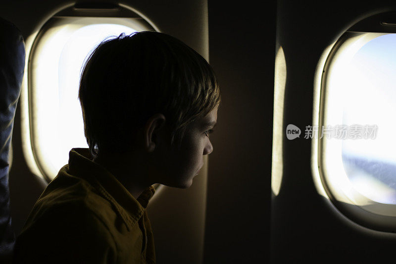 男孩望着飞机窗外
