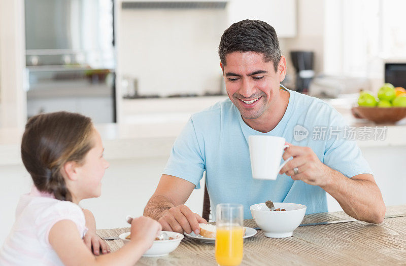 幸福的男人和女儿在厨房吃早餐