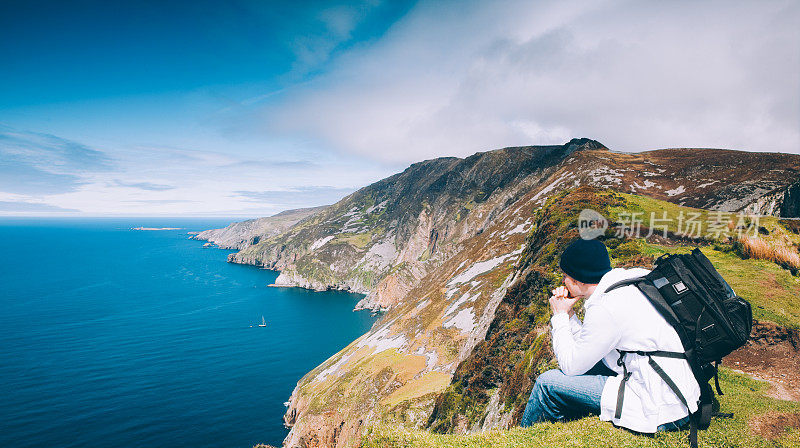 在斯克里夫联盟悬崖上的徒步旅行者欣赏大西洋的景色