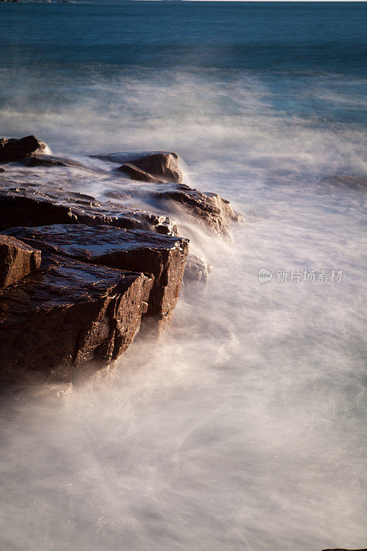 在阿卡迪亚国家公园，海浪拍打着布满岩石的海岸线