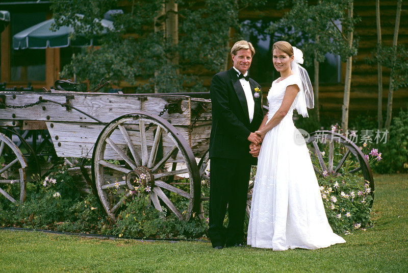 新娘和新郎坐在古董马车外