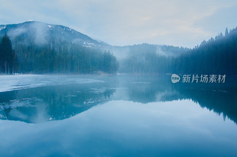 湖被山和森林包围的黄昏