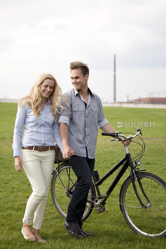 年轻夫妇手牵着自行车