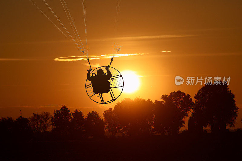 太阳上方的滑翔伞剪影