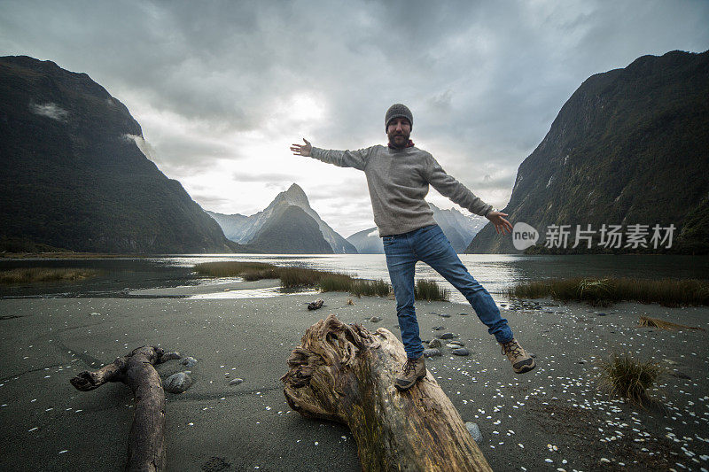 徒步者站在原木上，背景是群山