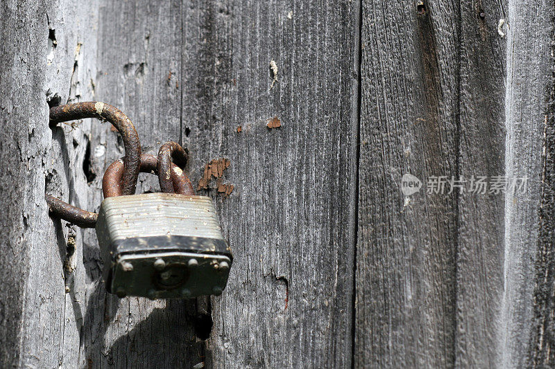 旧挂锁和生锈的戒指在灰色的木头背景