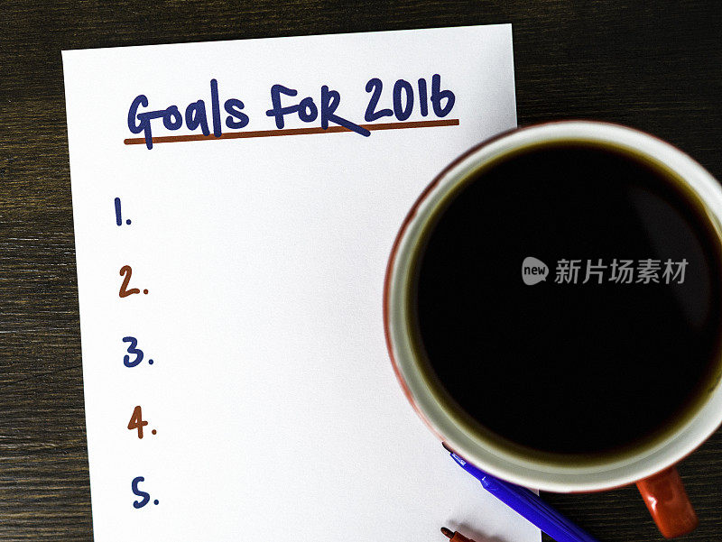 用笔在桌上写下2016年的新年目标清单