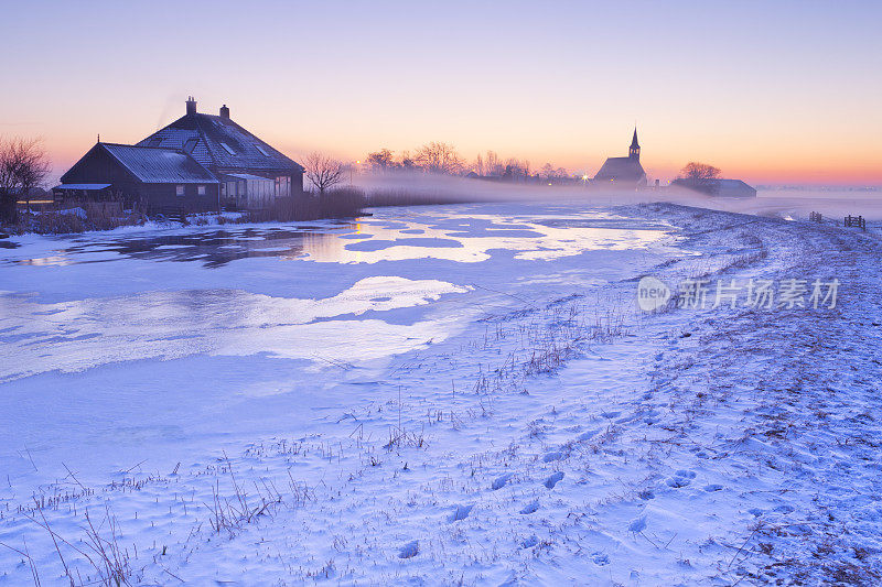 冬日日出时的农舍和教堂，荷兰欧登迪克