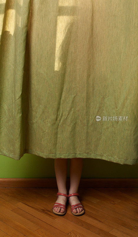 小女孩躲在窗帘后面