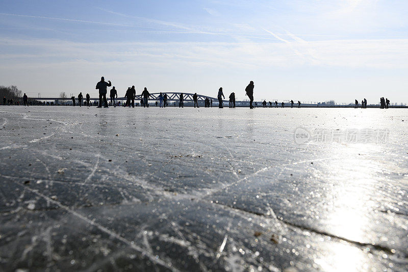 人们在兹沃勒附近的IJssel河边结冰的湖面上滑冰