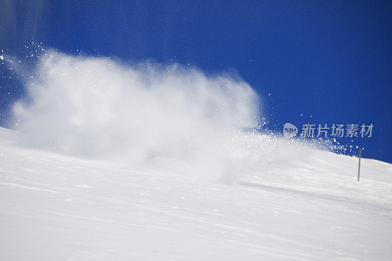 滑雪和单板滑雪的背景。雪飞溅。滑雪者在蓝天上转弯。大自然美丽的冬天。山顶上刚下过雪。高山景观滑雪场。
