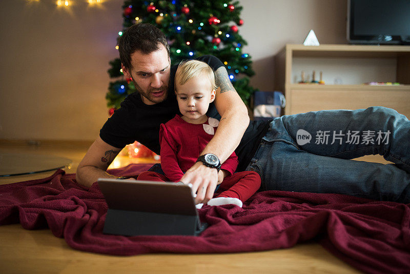 父亲和女儿在圣诞节使用电子平板电脑