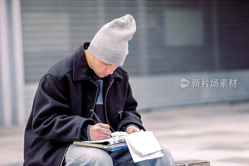 年轻的涂鸦艺术家在城市街道上素描