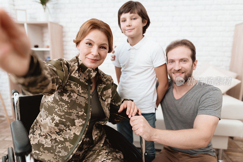 坐轮椅的退伍军人从军队回来。儿子和丈夫见到她都很高兴。
