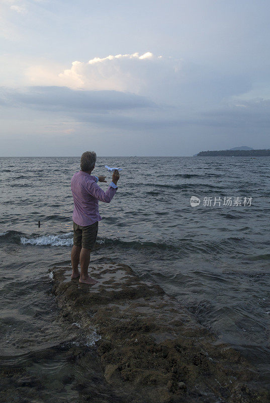 在浅滩的人发射纸飞机