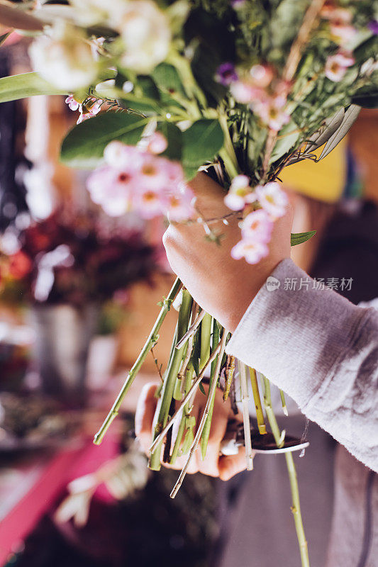 现代花匠工作与鲜花在车间-与手的细节