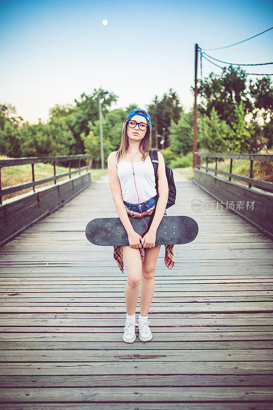 桥上的女孩拿着滑板