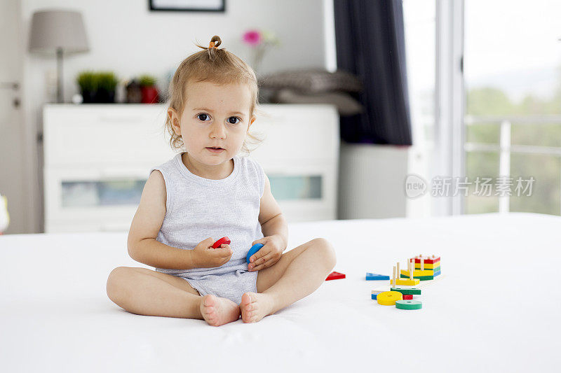 可爱的小女孩在玩木制玩具