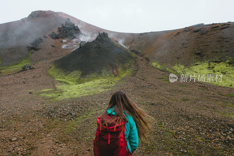 女子背包徒步旅行在地热地区的冰岛高地