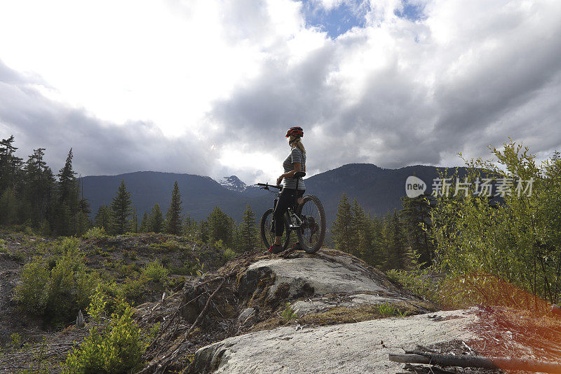 女山地自行车手停下来观看加拿大沿海的山脉