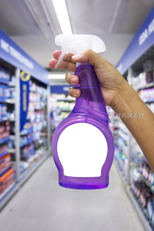 手拿紫色喷雾瓶和洗涤剂