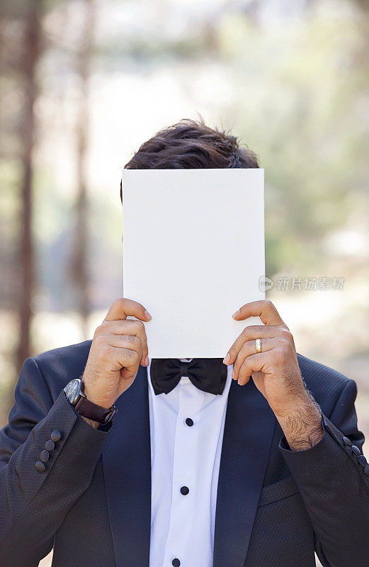 新郎用空白纸遮住脸。