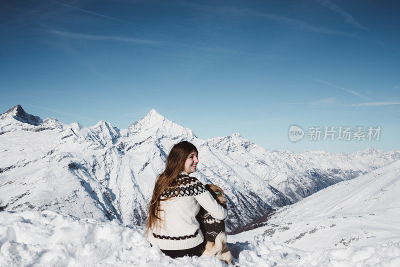 女人和狗享受瑞士阿尔卑斯山的冬季景色