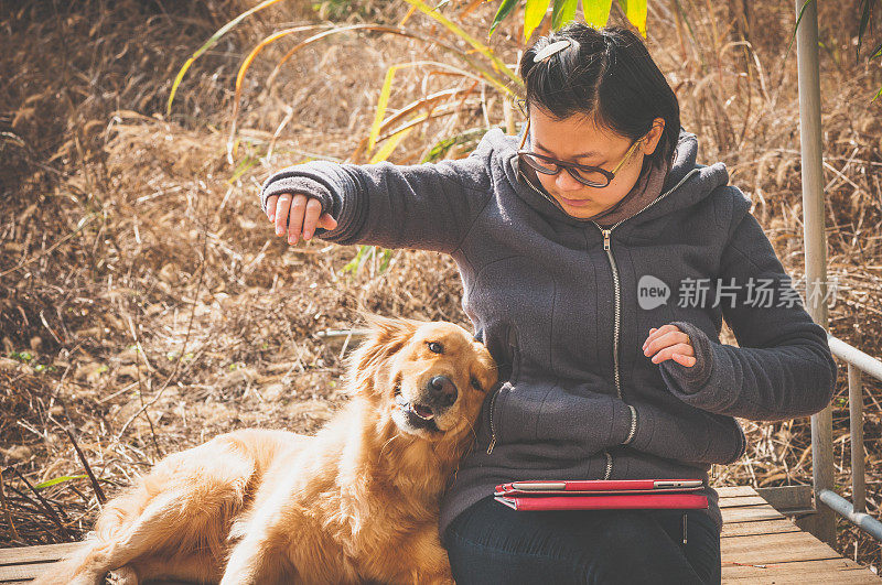 一个亚洲女人和一只金毛猎犬