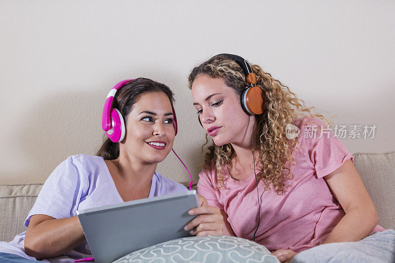 西班牙姐妹在数字平板电脑上听音乐