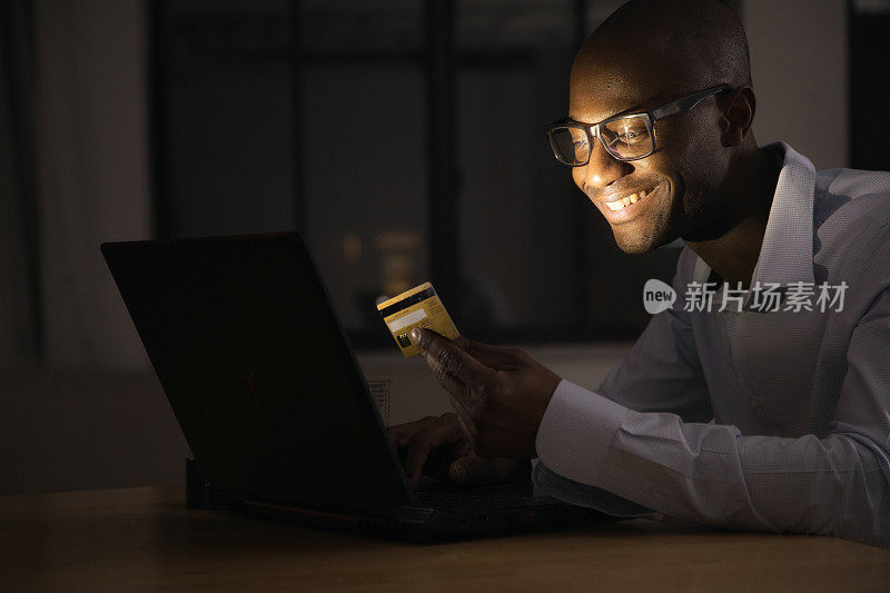 一个成熟的黑人大半夜用笔记本电脑在网上购物