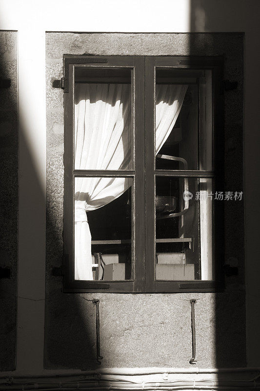 西班牙加利西亚的圣地亚哥德孔波斯特拉，古老的石头房子的窗户，黑白景色。