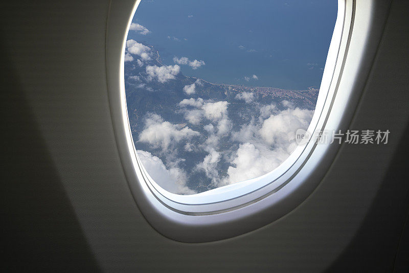 通过飞机窗口从空中俯瞰黑海海岸的飞机风景。