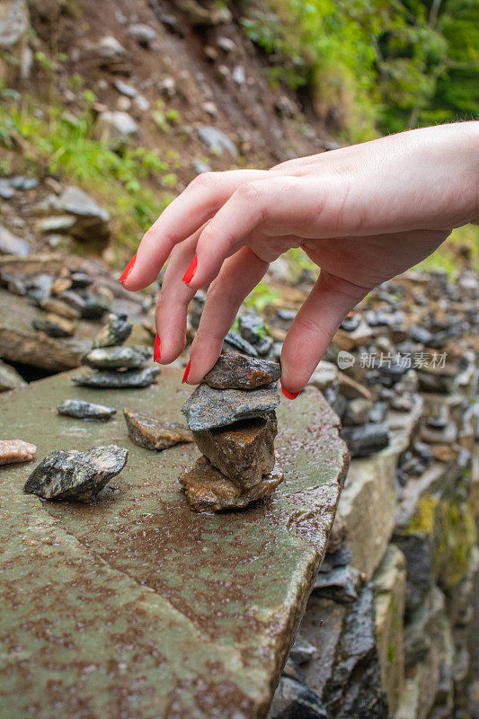 一个女孩的手堆起小石头的特写