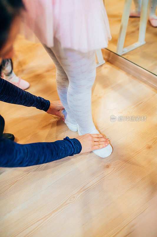 年轻的芭蕾舞演员在镜子前热身。儿童芭蕾舞者的腿或脚在芭蕾舞的位置。