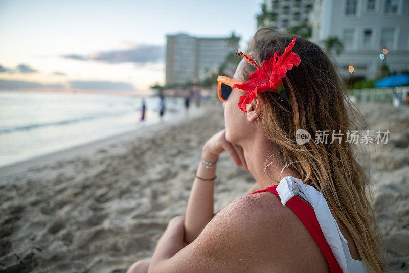 年轻女子在夏威夷威基基海滩上凝视日落