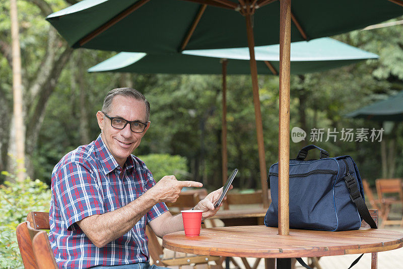 拉丁裔男子在一家漂亮的餐厅查看手机