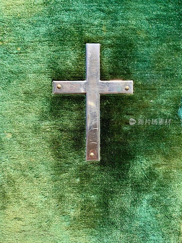 绿色背景上的银色十字架