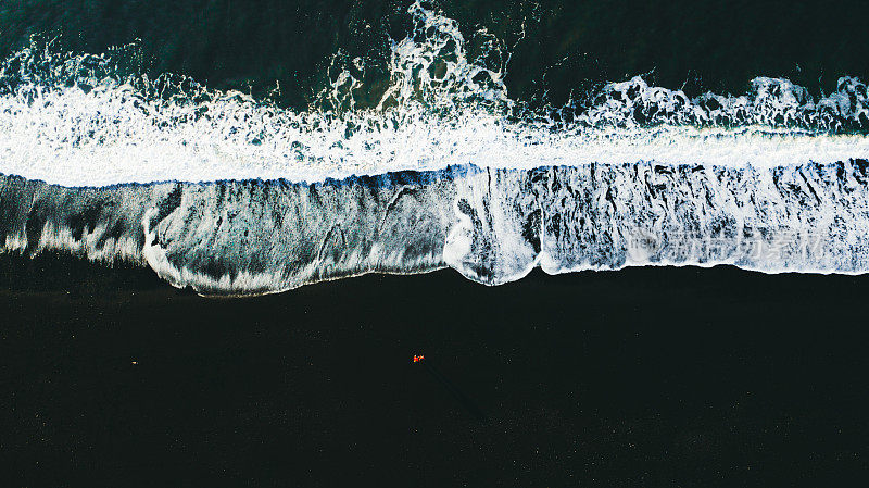 鸟瞰图的女人和男人在美丽的黑沙滩在冰岛