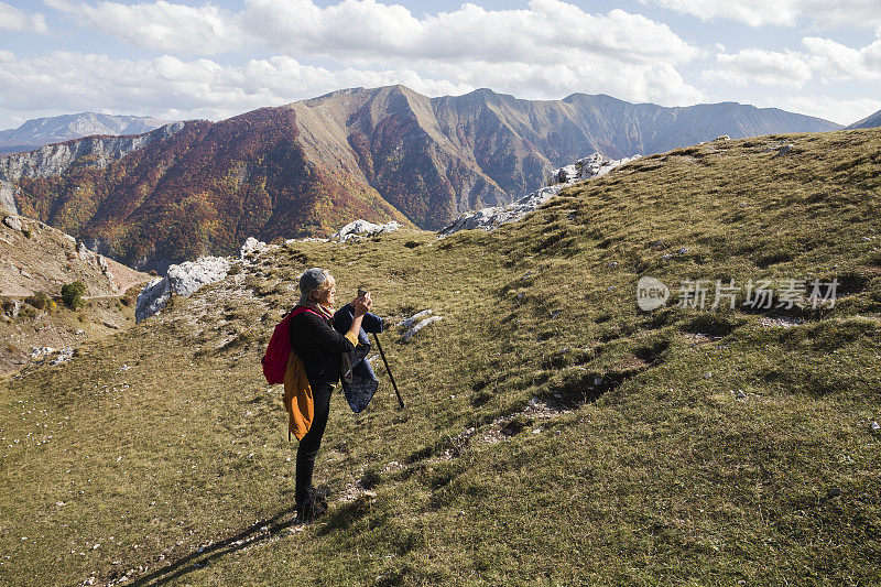 老奶奶在山上欣赏美丽的秋日