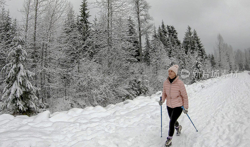 女性徒步旅行者沿着雪道行走