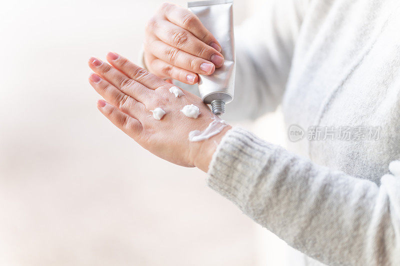 女人用护手霜在手上画笑脸