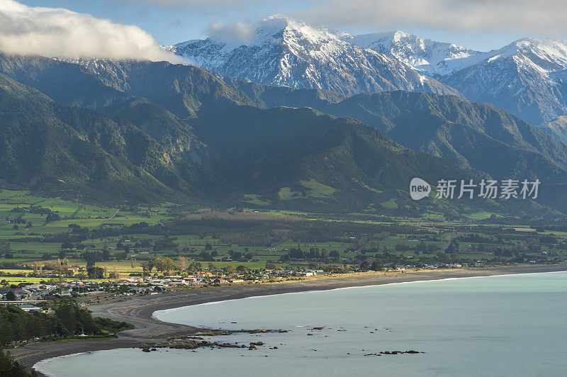 在新西兰一个晴朗的春天早晨，海边的凯库拉山脉和凯库拉镇