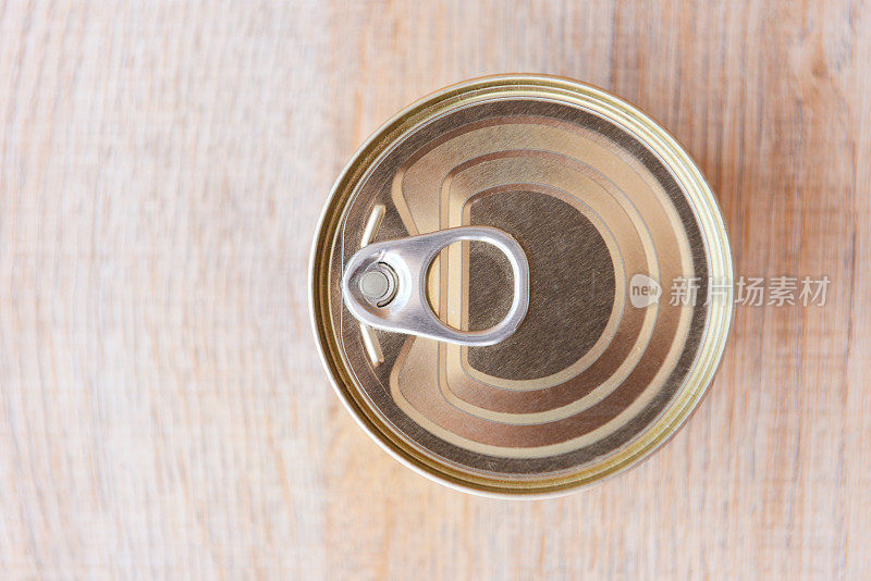各种罐头食品在金属罐头木质的背景上，俯视图-罐头食品不易腐坏的食品储存在厨房或家庭的物品捐赠