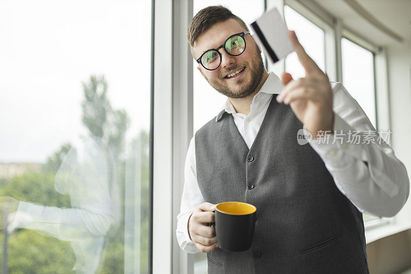 拿着信用卡喝咖啡的男人