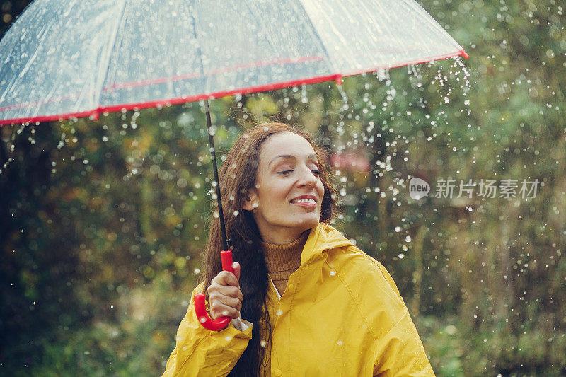 雨中快乐的女孩站在外面