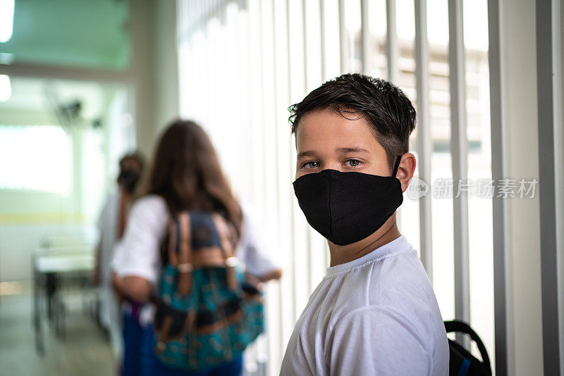 一个戴着口罩排队进入教室的男生的肖像