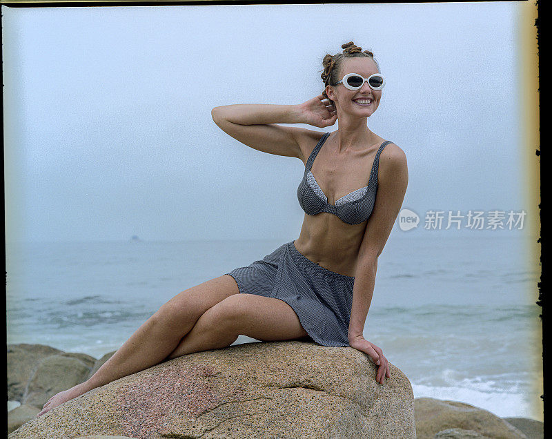 海报女郎在五十年代风格的比基尼，享受阳光和海滩。