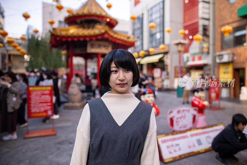 一个年轻女子走在日本神户的唐人街里