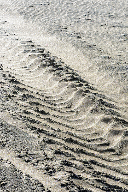 拖拉机轮胎在海边的沙滩上留下的痕迹